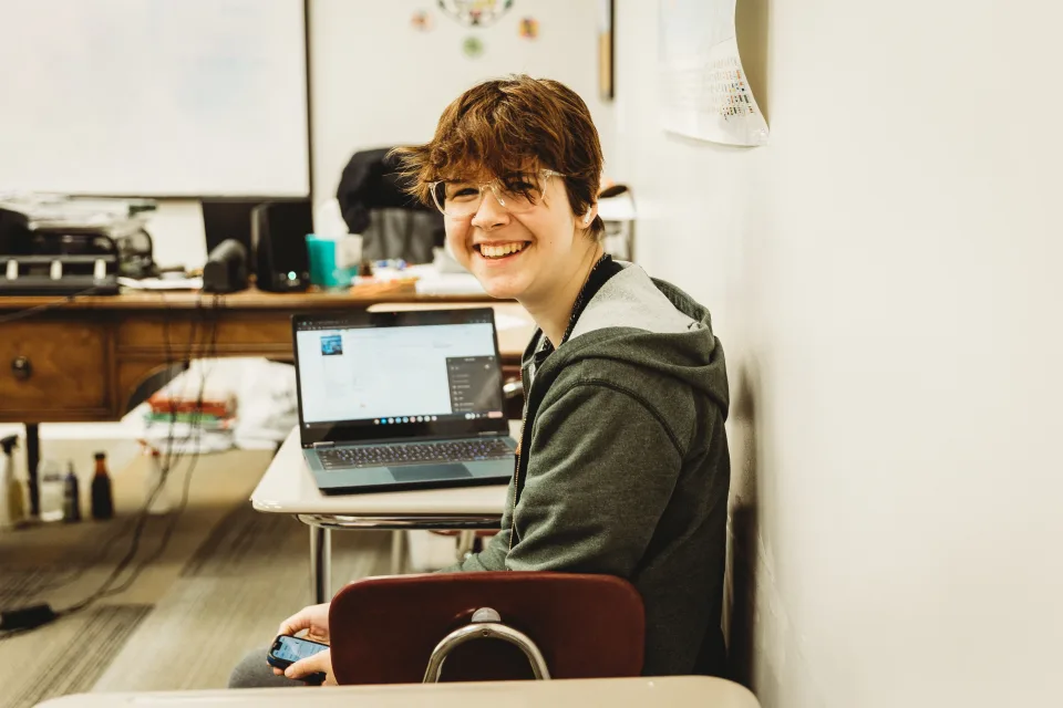 Happy student sitting at desk